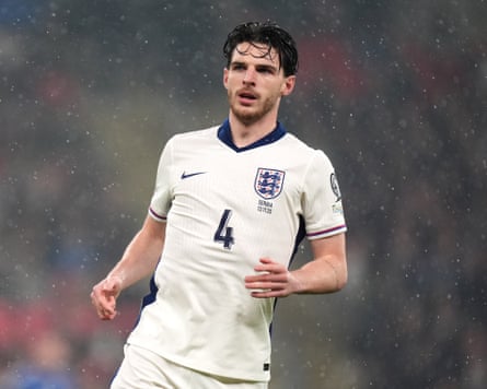 Declan Rice running across a pitch in the rain