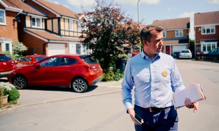 Calum Miller looking off camera while stood on a residential street with a car behind him