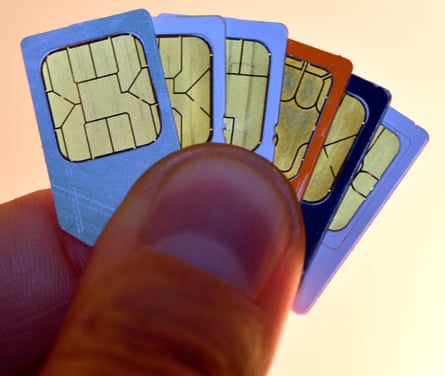 Mobile phone sim cards held between the fingers of a man