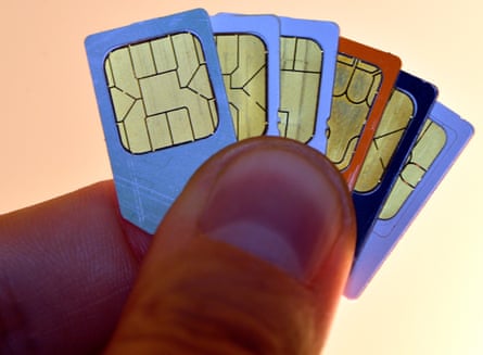 Cartões sim do telefone móvel mantidos entre os dedos de um homem