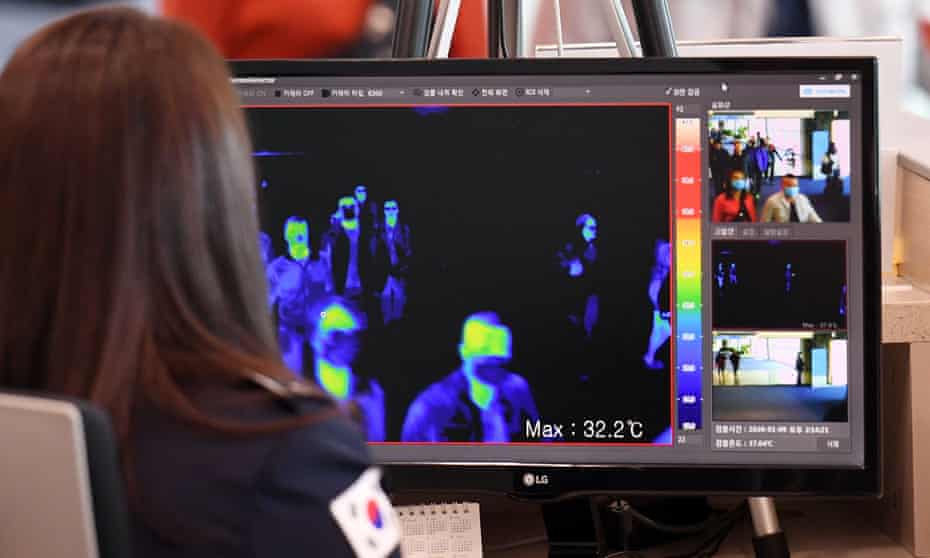 South Korean quarantine officials use thermal cameras to measure the temperatures of passengers arriving from China