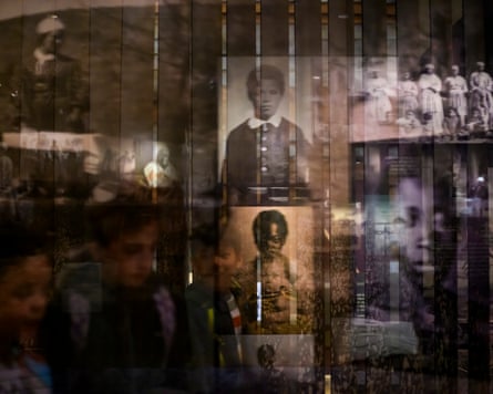 Visitors are seen amongst reflected images of enslaved people at the National Museum of African American History and Culture on November 19, 2025 in Washington, District of Columbia.