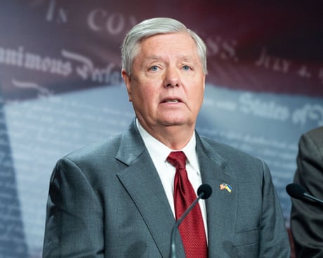 man in suit speaks into microphone