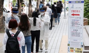 La gente hace cola para una prueba del virus corona en una clínica al aire libre en Puchion, Corea del Sur, mientras la ciudad introduce el reconocimiento facial impulsado por IA para rastrear los casos del gobierno.