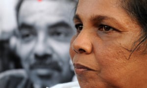 Sandhya Eknaligoda stands before an image of her husband, missing Sri Lankan cartoonist and journalist Prageeth Eknaligoda in 2012.