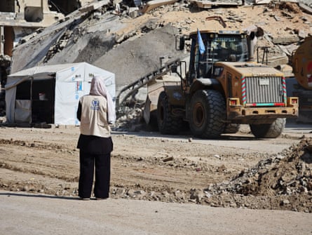 Woman in white WPF vest and scarf observes ruins