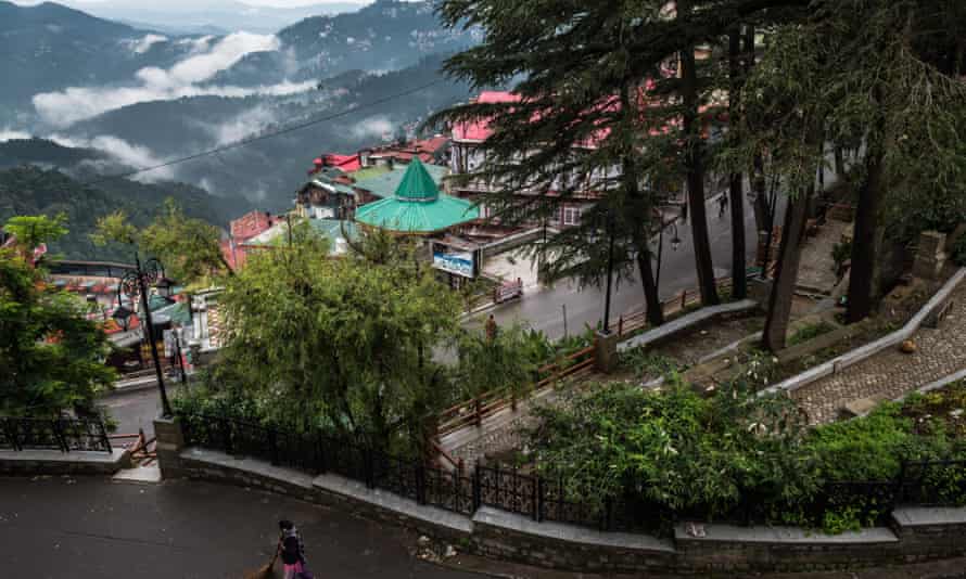 A woman sweeps the streets above Mall road in Shimla.
