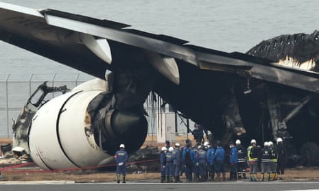 Tokyo police investigators inspect the wreckage of Japan Airlines passenger plane at Haneda Airport in Tokyo.