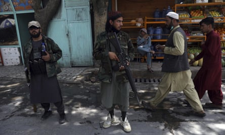 Taliban fighters stand guard at a checkpoint in the Wazir Akbar Khan neighbourhood