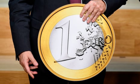 President of the ECB, Mario Draghi, holds a replica of a euro