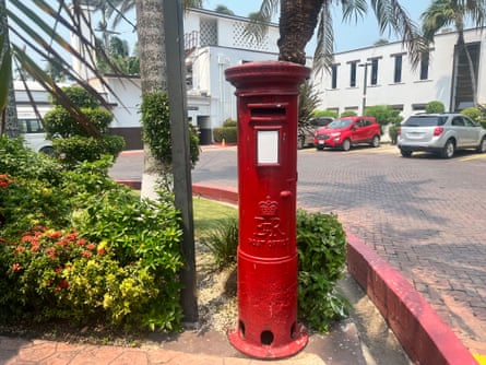 A red postbox on the grounds of a hotel in Belize City.