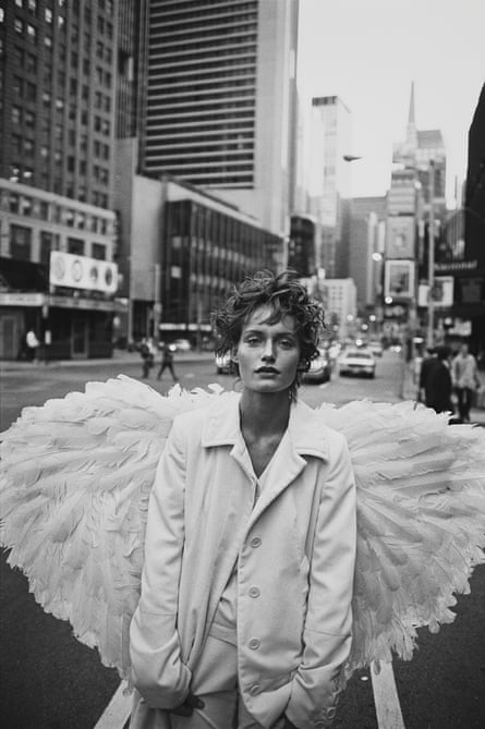 Amber Valletta in white and with large white wings in a New York street