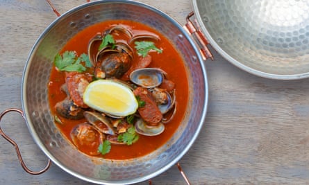 Clams with tomato, chorizo and coriander in a stainless steel bowl