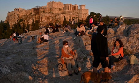 People enjoy a sunset in the Aeropagus hill overlooking the Ancient Acropolis in Athens as Greece gradually eases its lockdown against the spread of the COVID-19, the novel coronavirus, lifting up most of the restrictions on citizens’ movement. 