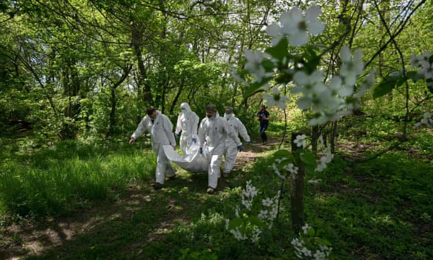 Ukrainian forensics experts carry the body of a Russian soldier exhumed in the village of Zavalivka, west of Kyiv.