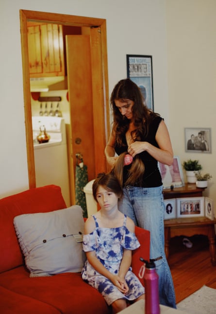 woman brushing daughter’s hair in a living room