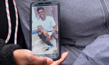 A relative of college football player Dwane Simmons shows his photo after he was shot dead last week