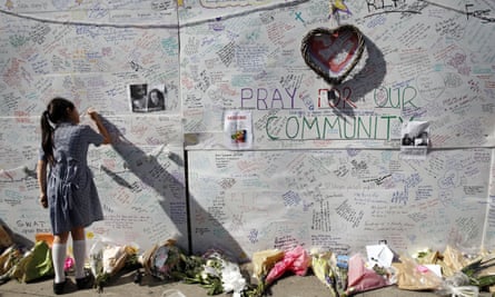 A schoolgirl writes a message on a wall for victims and survivors of the Grenfell Tower fire