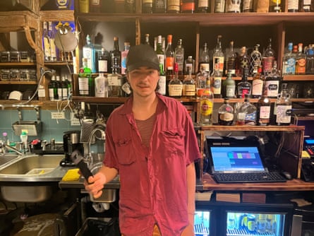 Young man with red shirt and baseball cap in a bar