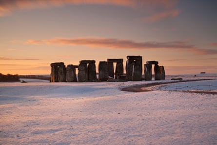 Stonehenge at sunrise with snow surrounding it
