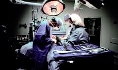 A surgical team performs a kidney transplant in an operating theatre.