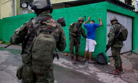 Brazilian soldiers frisk a resident during an operation in the City of God favela in Rio de Janeiro, Brazil. 