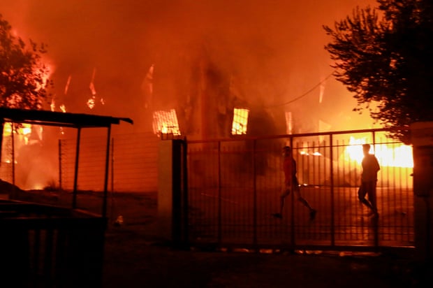 Men run to escape the fire at Moria on Wednesday