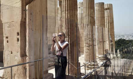A visitor taking photos at the Acropolis in Athens