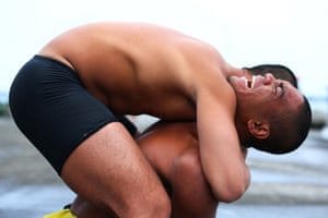 Ou Zhi-Xuan, 25, cries in pain as a fellow trainee helps him stretch