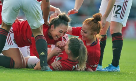 Manchester United players celebrate with their captain Katie Zelem, centre, after she had opened the  scoring against City from a free-kick.
