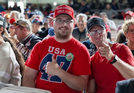 two men in caps and red shirts gesture with their hands
