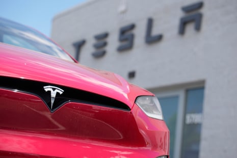 grille of model x in red outside building that says 'tesla'
