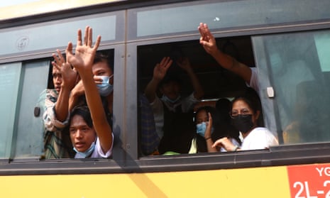 Arrested protesters wave from a bus after their release from Insein prison in Yangon