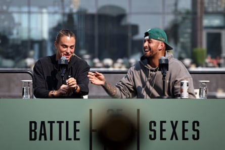 Sabalenka and Kyrgios sitting adjacent to each different successful beforehand of microphones astatine a array pinch ‘Battle of nan Sexes’ written connected nan beforehand of it