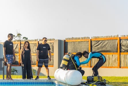 Nkosi helps Husna Amimu put on her dive gear while Noel Kok and Pragna Parsotam-Kok look on