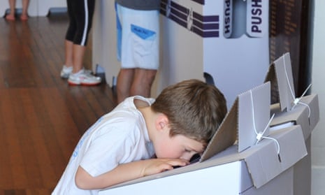 A young boy looks into a ballot box in Sydney.