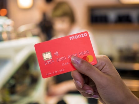 A hand holding a monzo card