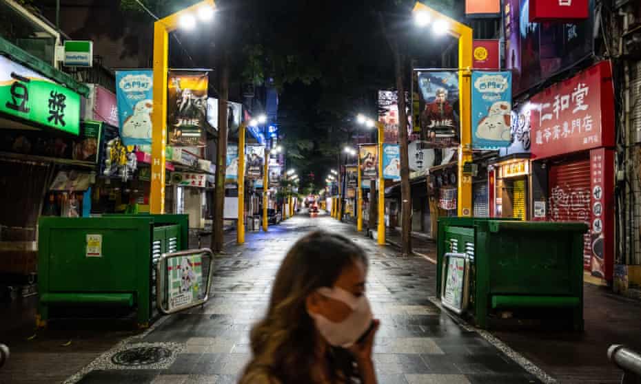 Pedestrian wearing protective masks walks along a street on June 1, 2021 in Taipei, Taiwan