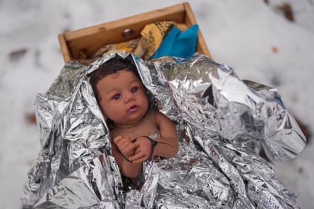 baby doll covered in foil with hands zip-tied