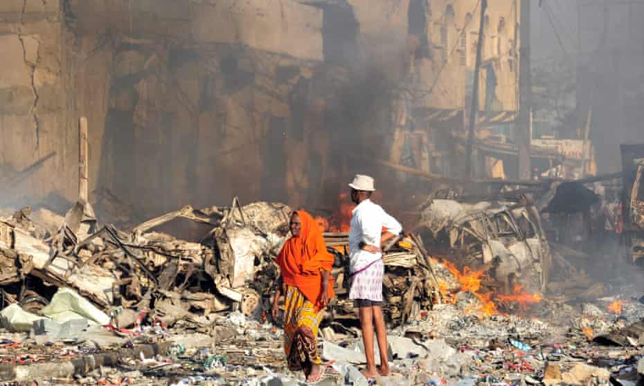 A man and woman look at the damage on the site of the explosion of a truck bomb in the centre of Mogadishu
