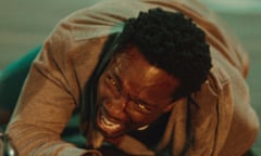 Tosin Cole as Michael, grimacing with weird golden eyes