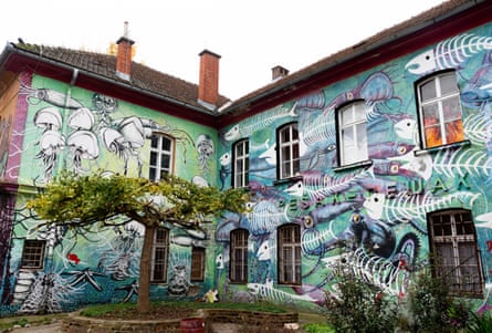 A two-storey building covered in a painting of aquatic creatures and fish skeletons