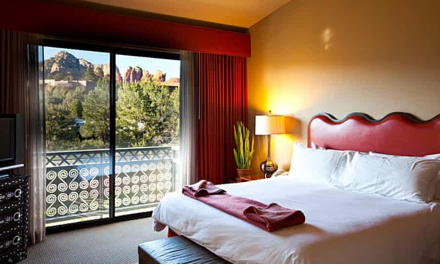 A bedroom with a view of the mountains at Sedona Rouge hotel, Sedona, Arizona, US.