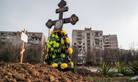 Graves of civilians killed during the Ukraine-Russia conflict are seen next to apartment buildings in the southern port city of Mariupol, Ukraine