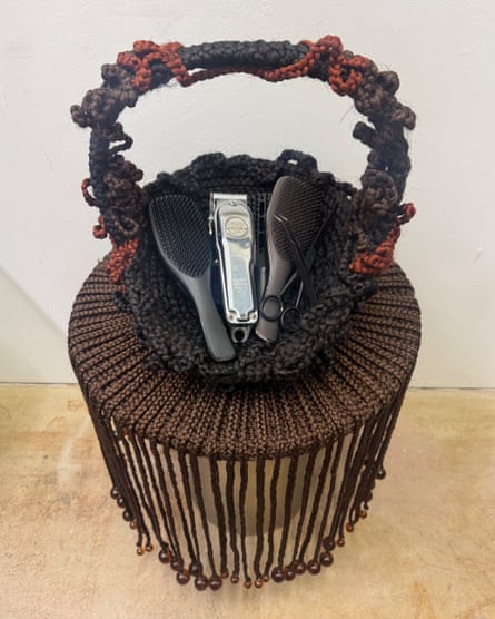 A table with braids and beads hanging off it, with a basket made from hair on top