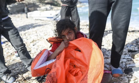 A young girl blows up a life jacket