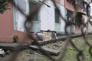 A coffin with the body of a person who is believed to have died from Covid-19 lies wrapped in plastic and covered with cardboard, outside a block of family apartments in Guayaquil.
