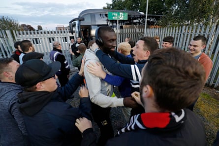 Ousseynou Cisse of MK Dons is encouraged by away fans after he got off the team bus.