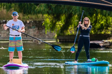 Adam Partington and Gemma Cann paddleboarding in Cambridge.