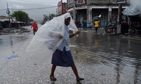 A woman in Port-au-Prince protects herself from the first rains brought on by Hurricane Matthew.